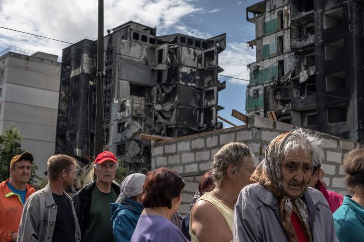 Humanitárius segélyre várakoznak emberek orosz tüzérségi támadásban megrongálódott lakóépületek mellett a Kijev közelében lévő Borodjankában 2022. június 21-én. Fotó: MTI/EPA 