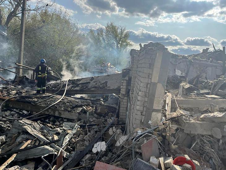 Az ukrán elnöki sajtóiroda által közreadott képen tűzoltó a romok között Hrozában 2023. október 5-én, miután orosz rakétatámadás érte a kelet-ukrajnai Harkiv közelében fekvő falut. Fotó: MTI/AP/Ukrán elnöki sajtóiroda