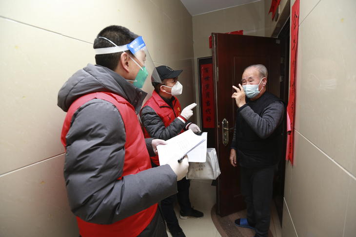 A koronavírus-járvány miatt arcpajzsot viselő önkéntesek felírják, hogy milyen alapvető dolgokra van szüksége egy lakónak az északnyugat-kínai Senhszi tartománybeli Hszian egyik lakónegyedében 2022. január 3-án. MTI/AP/Chinatopix 