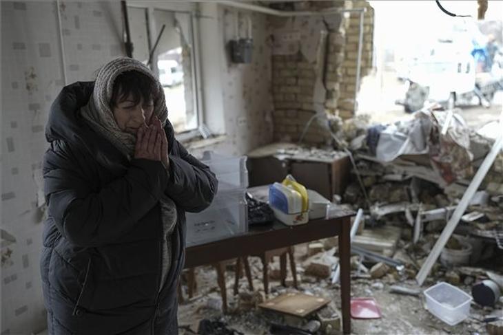 A 69 éves ukrán Halina Panasian áll orosz rakéta becsapódása következtében megsemmisült otthona egyik szobájában a Kijev megyei Hlevakha településen. Fotó: Facebook