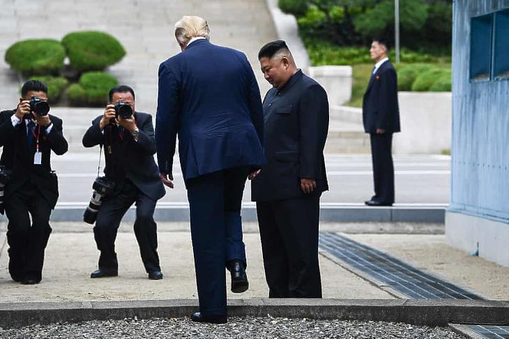 Donald Trump (középen, balra) átlép Észak-Koreába, miután a demilitarizált övezetben találkozott Kim Dzsong Unnal (középen, jobbra). (Fotó: Brendan Smialowski/AFP/Getty Images)