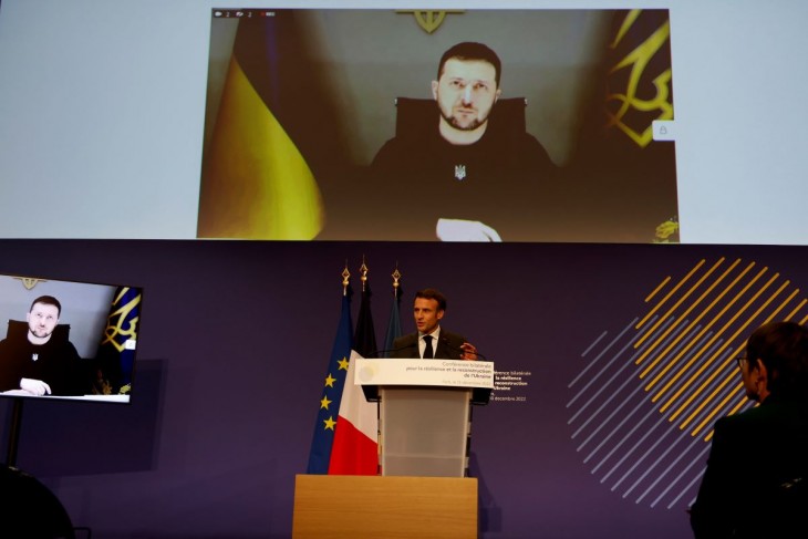 Emmanuel Macron francia elnök felszólalását hallgatja Volodimir Zelenszkij ukrán államfő (kivetítőn) az Ukrajna sürgős szükségleteinek kezeléséről szóló nemzetközi konferencián Párizsban 2022. december 13-án. Fotó: MTI/EPA/AFP