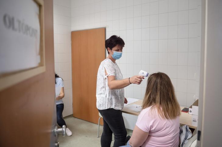 Megmérik egy nő testhőmérsékletét, mielőtt beoltják a harmadik körös Covid-vakcinával 2022. május 31-én. Fotó: MTI/Komka Péter