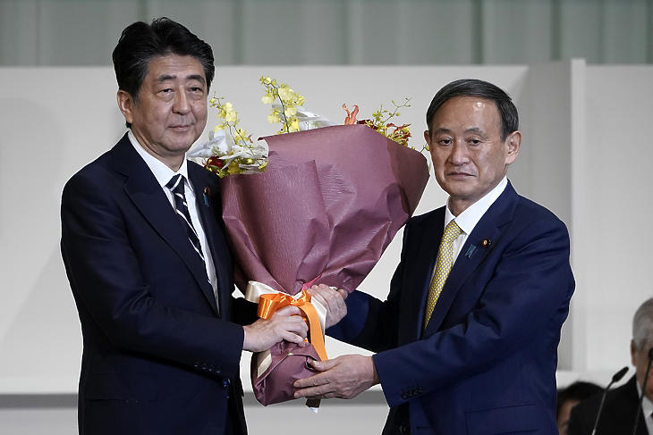 Abe Sindzó japán miniszterelnök (b) virágot nyújt át Szuga Josihide kormányszóvivőnek, miután utóbbi megnyerte a japán kormánypárt, a Liberális Demokrata Párt (LDP) új vezetőjének megválasztására kiírt szavazást Tokióban 2020. szeptember 14-én. Szuga miniszterelnöknek való megválasztása tulajdonképpen már csak formaság volt. (Fotó: MTI/AP pool/Eugene Hoshiko)