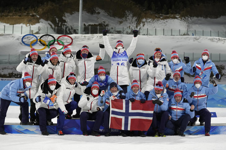 Az összesen négy arany- és egy bronzérmet nyerő Johannes Thingnes Bø (k) csapatársaival ünnepel a férfi sílövők 10 kilométeres sprintversenye után a 2022-es pekingi téli olimpián 2022. február 12-én. (Fotó: MTI/AP/Kirsty Wigglesworth)