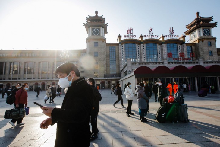 Védőmaszkos emberek a pekingi főpályaudvar előtt 2023. január 10-én. A kínai holdújév, a Nyúl éve idén január 22-én köszönt be, és ilyenkor hagyományosan százmilliók kelnek útra, hogy a családjuk körében töltsék el a tavaszünnepet, miközben emelkedik a koronavírussal fertőzöttek száma az országban. Fotó: MTI/EPA