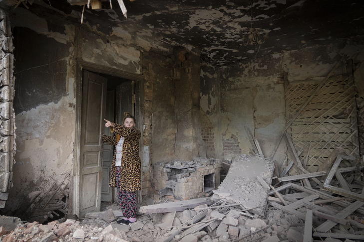 Orosz tüzérségi támadásban megrongálódott házának romjait mutatja egy nő a kelet-ukrajnai Bahmutban 2022. június 24-én. Fotó: MTI/AP/Efrem Lukackij