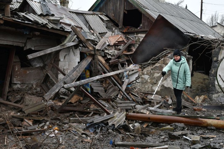 Épület romjai mellett egy nő a kelet-ukrajnai Donyecki területen fekvő Kurahovéban egy előző napi orosz tüzérségi támadás után, december 8-án. Fotó: MTI/AP/Andrij Andrijenko
