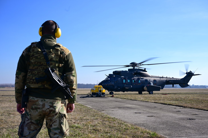 Katona egy Airbus H225M típusú helikopter mellett a nyíregyházi repülőtéren 2026. március 1-jén. A Védelmi Tanács döntése alapján két helikopter látja el a légi légvédelmi feladatokat. 