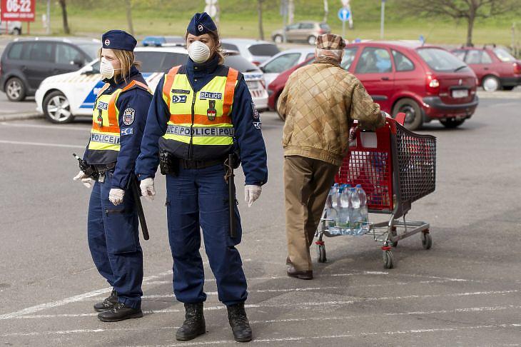 Rendőrök járőröznek egy győri bevásárlóközpont parkolójában a kijárási korlátozás alatt 2020. március 30-án. (Fotó: MTI/Krizsán Csaba)