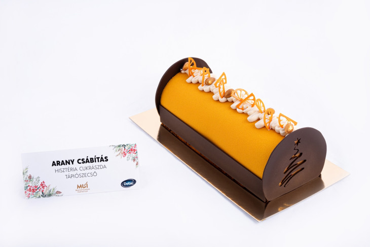 Az aranyérmes termék, az ARANY CSÁBÍTÁS, mandulalisztes kakaós felverten, narancsos ropogós réteggel, karamellizált csokoládé- és narancsos tejcsokoládé mousse-szal és mandula chantilly-val készült különlegesség. Füredi Krisztián, a tápiószecsői Hisztéria Cukrászda alkotása.