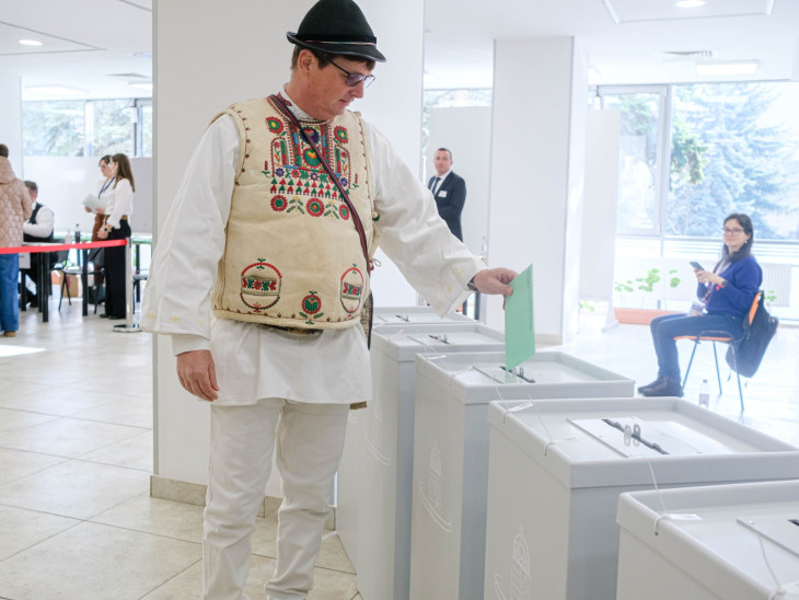 Csángó népviseletbe öltözött férfi leadja szavazatát az országgyűlési választáson a csíkszeredai főkonzulátus által a Sapientia Erdélyi Magyar Tudományegyetem épületében kialakított szavazókörben 2026. április 12-én.