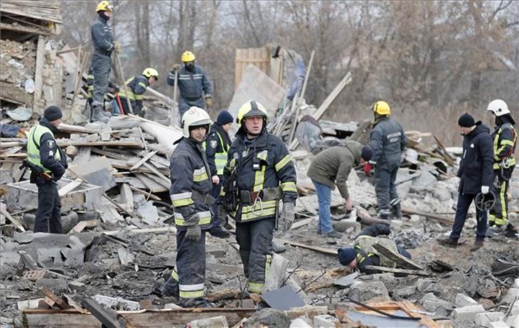 Tűzoltók egy orosz rakétatámadás következtében megsemmisült lakóház romjai között Kijev határában. Fotó: MTI/EPA/Szerhij Dolzsenko