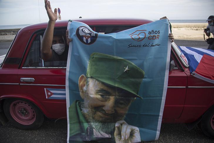 Kormánybarát kubaiak Fidel Castrónak, a kubai kommunista forradalom egykori vezetőjének a plakátját lógatják ki egy autó ablakán Havannában a Fiatal Kommunisták Szövetsége felhívására tartott megmozduláson 2021. augusztus 5-én. (Fotó: MTI/AP/Ismael Francisco)
