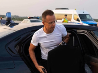 Szijjártó Péter egy BMW-ből száll ki
