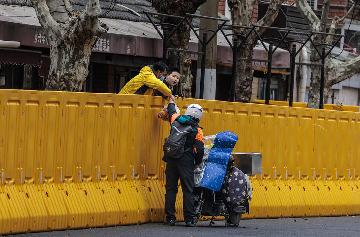 Sanghaj lezárt részére kézbesít rendelést egy ételfutár. Az étel- és csomagrendelések számának alakulása is elárulhat valamit a gazdaság állapotáról. Fotó: MTI/EPA/Alex Plavevski 