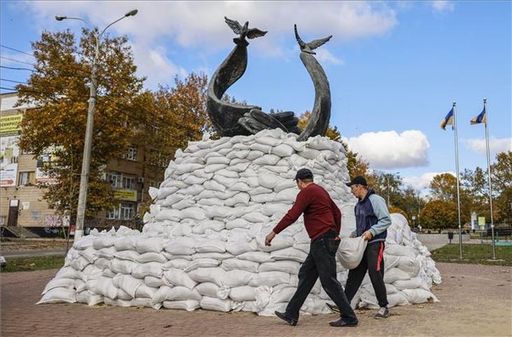 Az orosz tüzérségi támadások elleni védekezésképpen homokzsákokkal vesznek körül egy hősi emlékművet a dél-ukrajnai Mikolajivban 2022. október 31-én. Fotó: MTI/EPA/Hannibal Hanschke