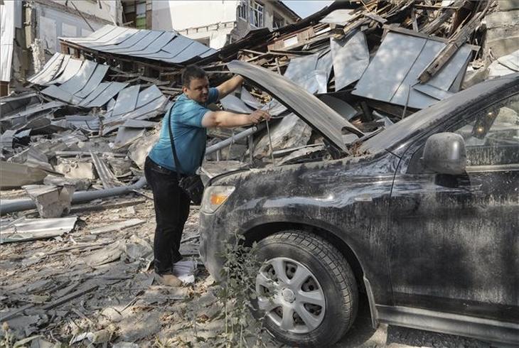 Egy harkivi oktatási intézmény romba dőlt épülete mellett nézi meg sérült autóját egy férfi 2022. augusztus 19-én, miután orosz rakétatámadás érte a kelet-ukrajnai várost. Ukrán források szerint egy nő életét vesztette. MTI/EPA/VASILIY ZHLOBSKY