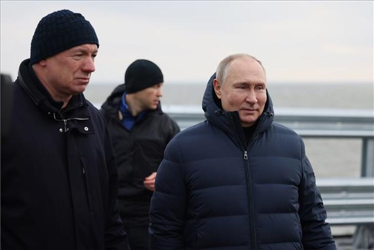 Vlagyimir Putyin orosz elnök (j) Marat Husznullin miniszterelnök-helyettes (b) társaságában megnézi az Ukrajnától elcsatolt Krímet és Oroszországot a Fekete- és az Azovi-tenger között összekötő hidat 2022. december 5-én, miután befejeződött a létesítmény helyreállítása. A hídon október 8-án felrobbant egy teherautó, az útpálya érintett szakasza beomlott és a vasúti híd szerkezete is megsérült. Fotó: MTI/EPA/Szputnyik/Orosz elnöki sajtószolgálat/Mihail Metzel
