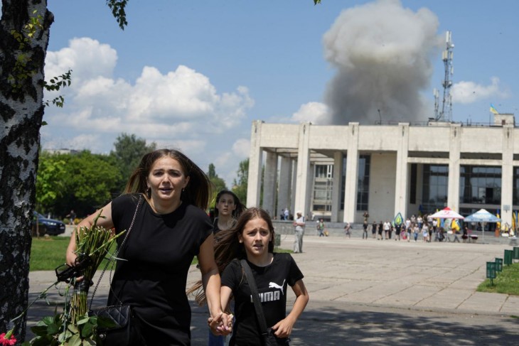 Helybeliek menekülnek a robbanások elől egy orosz rakétatámadás idején a délkelet-ukrajnai Harkivi területen levő Pervomajszkijban 2023. július 4-én. Az ukrán hatóságok szerint a légicsapásban legkevesebb harmincegyen megsebesültek, köztük kilenc gyermek. Fotó: MTI/AP