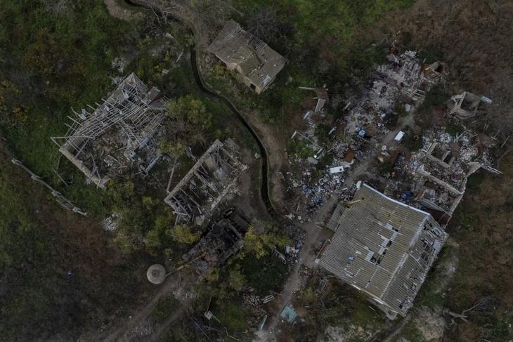 Orosz páncélozott harci jármű maradványa lerombolt lakóházak között az ukrán fennhatóság alá visszakerült dél-ukrajnai Herszon közelében fekvő falvak egyikében. Fotó: MTI/AP/Bernat Armangue