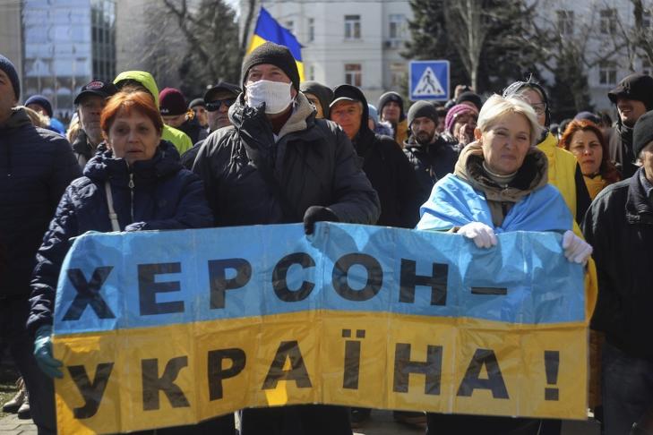 Herszon Ukrajna feliratú transzparenst tart két tiltakozó az orosz csapatok támadása elleni tüntetésen. Fotó: MTI/AP/Olexandr Chornyi 