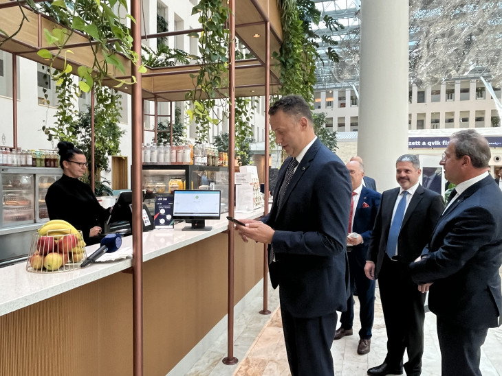 Virág Barnabás, az MNB korábbi alelnöke qvik tranzakcióval fizet egy büfében &ndash; a háttérben Csányi Péter, az OTP Bank vezérigazgatója és Zolnay György, a Raiffeisen Bank vezérigazgatója