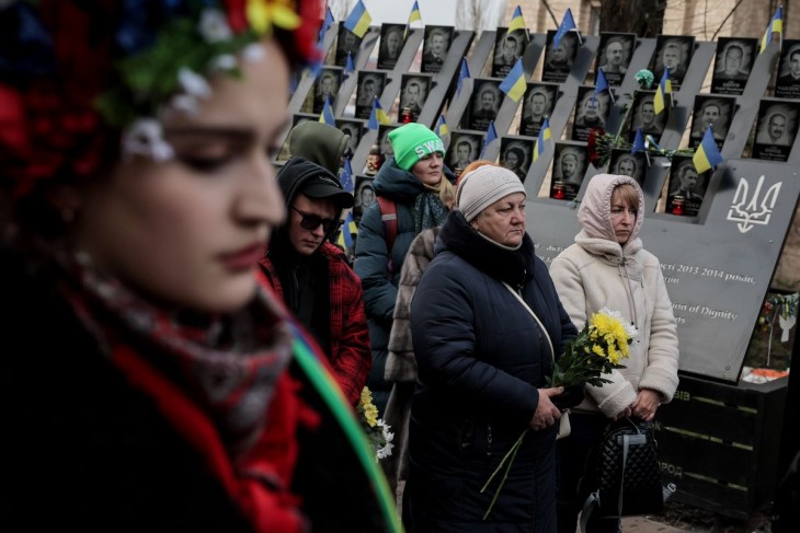 Virágot hagy egy nő a Majdan-tüntetések halálos áldozatainak emlékfalánál Kijevben 2023. november 21-én. Tíz évvel korábban ezen a napon kezdődtek az Euromajdan ukrán ellenzéki társulás erőszakossá fajuló kormányellenes tiltakozásai Kijev főterén, a Majdanon. A megmozdulásokat Ukrajna európai uniós csatlakozása mellett, és Viktor Janukovics akkori ukrán államfő ellen szervezte a mozgalom. Fotó: MTI/EPA