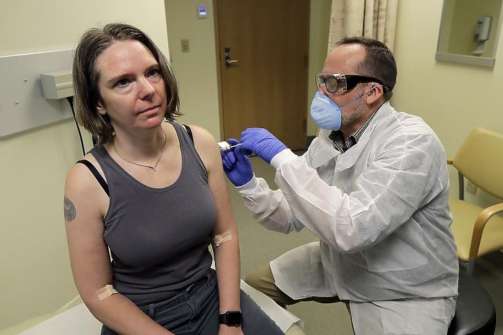 Jennifer Haller amerikai nő az új koronavírus ellen készített, első fokozatban, klinikai kísérleti stádiumban lévő oltóanyagot kap egy gyógyszerésztől a seatlle-i Kaiser Permanente Washington Egészségügyi Kutatóintézetben 2020. március 16-án. MTI/AP/Ted S. Warren