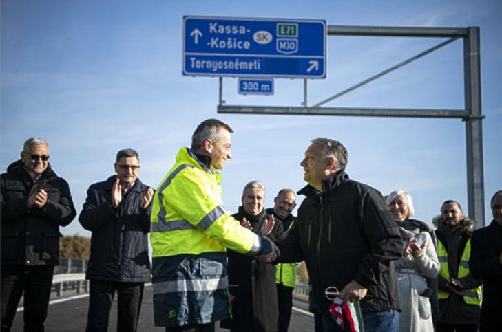 Orbán Viktor miniszterelnök és Szász Róbert, a Nemzeti Infrastruktúra Fejlesztő Zrt. (NIF Zrt.) projektvezetője kezet fog, miután átvágták a nemzeti színű szalagot (Fotó: MTI/Miniszterelnöki Sajtóiroda/Benko Vivien Cher)