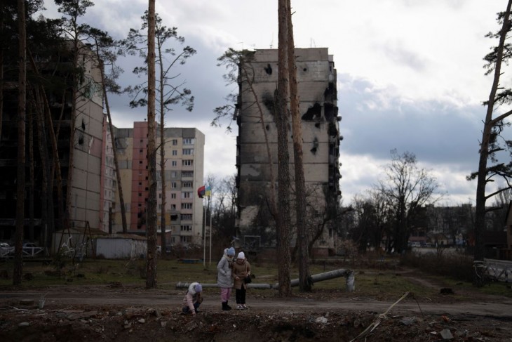 Lányok sétálnak az orosz támadások során megrongálodott lakóépületek között az ukrán főváros, Kijev közelében fekvő Irpinyben 2023. február 26-án. Fotó: MTI/AP