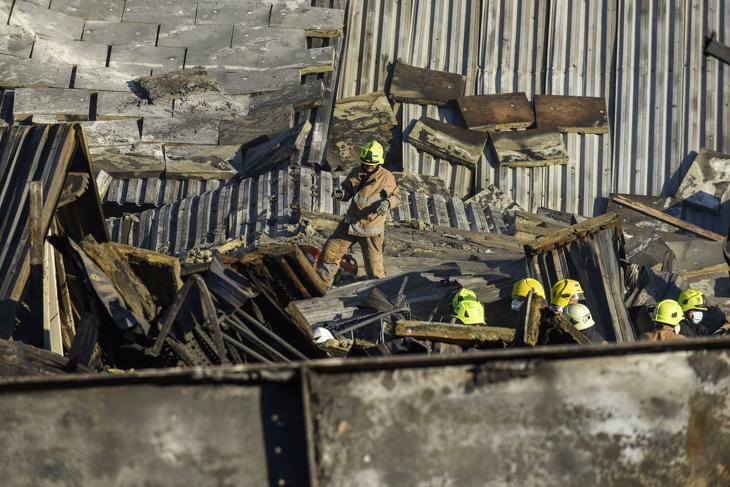 A kremencsuki bevásárlóközpont romjai között tűzoltók keresik a túlélőket 2022. június 28-án. Fotó: MTI/EPA