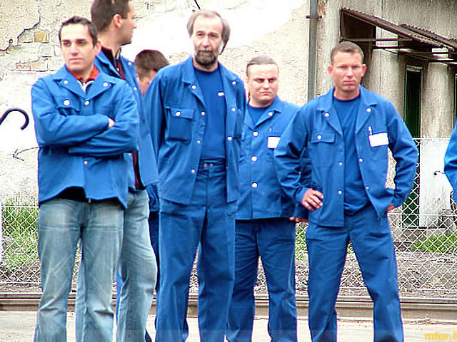 Az első fecskék: magyar munkások a Stadler-gyárban. A háttérben a vasútállomás omladozó épülete.