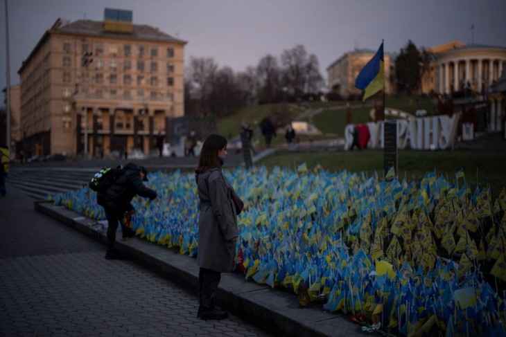 Az ukrajnai háborúban elesettek emlékére elhelyezett zászlókat nézi egy nő a kijevi Függetlenség (Majdan) tere közelében 2023. január 20-án. Fotó: MTI/AP