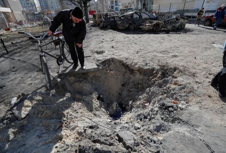 Egy bombatámadás során létrejött krátert néz egy idős férfi Kijevben 2022. február 28-án. Fotó: MTI/EPA