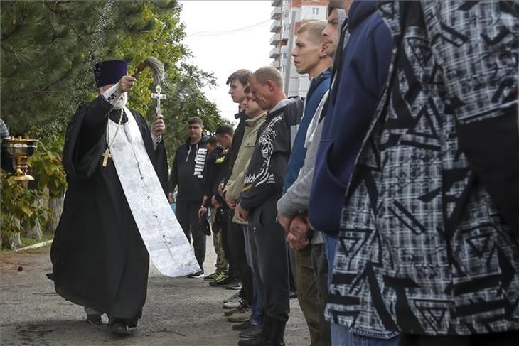 Egy ortodox pap megáldja az újonnan érkezőket egy volgográdi toborzó központban 2022. szeptemberében. Továbbra is nagy szükség lenne az új katonákra. Fotó: MTI/AP 