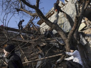 Önkéntesek takarítják a december 31-i orosz támadásban megsemmisült házak romjait Kijevben 2023. január 3-án. Fotó: MTI/EPA/Mihail Palincsak