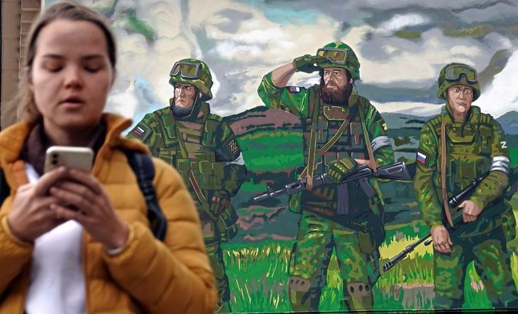 Az Oroszországnak az Ukrajna ellen indított különleges katonai hadműveletét támogató falfestmény előtt megy egy nő Moszkvában 2022. szeptember 20-án. MTI/EPA