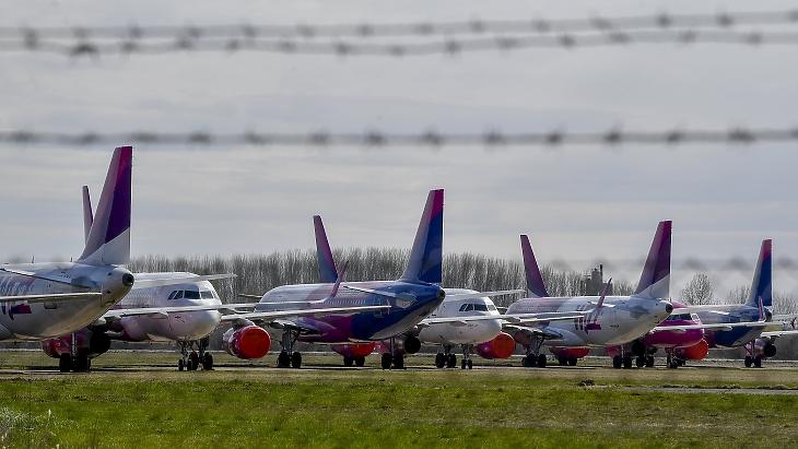 A Wizz Air repülőgépei parkolnak a Debreceni Nemzetközi Repülőtér kifutópályája mellett 2020. március 22-én, a koronavírus-járvány első hulláma idején. Törölt, illetve ideiglenesen szünetelő járatok tekintetében most sem fényesebb a kép. Fotó: MTI/Czeglédi Zsolt