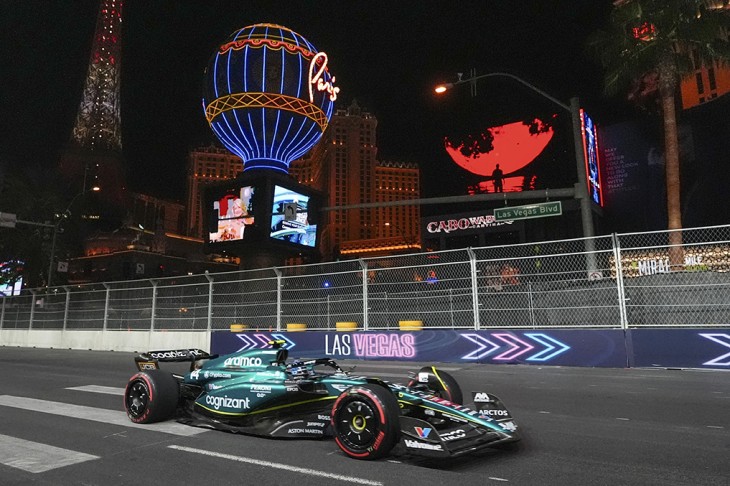A körítés vagy a verseny a lényeg? Fernando Alonso halad a Las Vegas-i pálya különleges aszfaltján, a háttérben néhány ikonikus látványossággal. Fotó: MTI/AP/Nick Didlick 