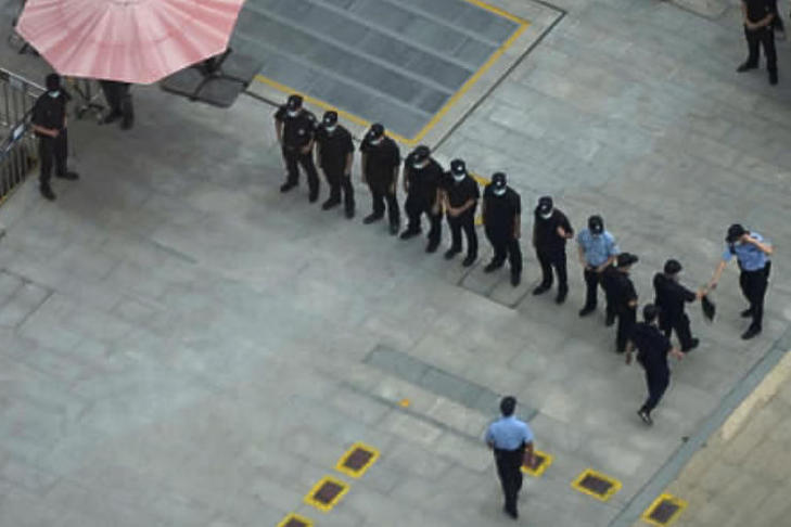 Rendőrök és biztonsági őrök felsorakoznak a China Evergrande kínai ingatlanfejlesztő csoport székháza előtt Sencsenben 2021. szeptember 23-án.  (Fotó: MTI/AP)