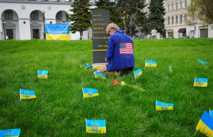 Az orosz-ukrán háborúban meghalt külföldi állampolgároknak állít emléket kis zászlókkal egy férfi Kijev egyik parkjában 2022. április 30-án. Fotó: MTI/AP