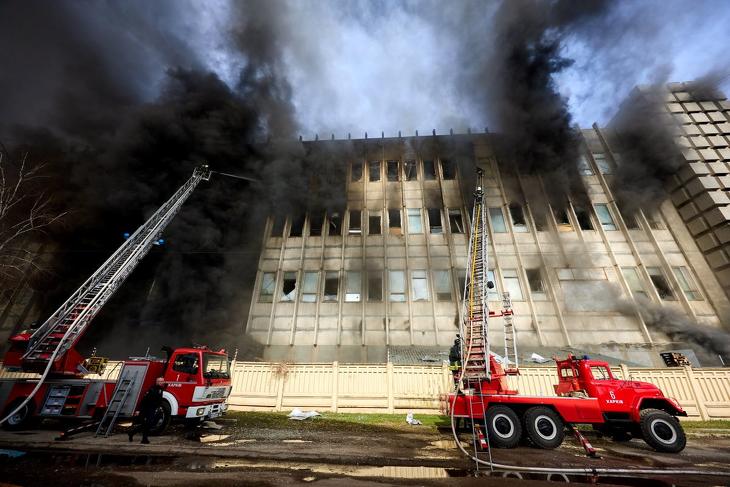 Ukrán tűzoltók próbálják megfékezni egy orosz rakétatalálatot kapott ipari épület lángjait a kelet-ukrajnai Harkiv város Holodnohirszk kerületében 2024. március 20-án.