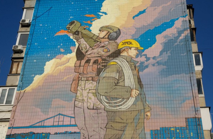 2023. november 30-i felvétel egy óriási festményről egy kijevi lakótömb oldalán. Az Ukrajna védelmezői előtt tisztelgő falfestményt Andrii Kovtun és Anton Kudrjasov ukrán művész készítette, és november 30-án avatták fel. Az alkotók A fény védelmezői címet adták a műnek, amely egy ukrán katonát ábrázol légvédelmi rakétavetővel a vállán, és egy villamossági szakembert, aki a megrongált elektromos hálózatok javítását végzi. Oroszország 2022. február 24-én indított hadműveletet Ukrajna ellen. Fotó: MTI/EPA