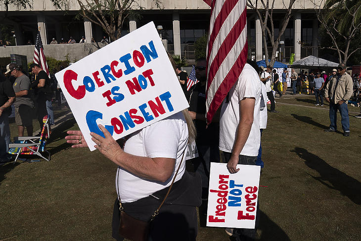A koronavírus elleni oltás kötelezővé tétele ellen tüntetnek Los Angelesben 2021. november 8-án. A táblák felirata: A kényszerítés nem beleegyezés; Szabadság nem erőszak. (Fotó: MTI/AP/Jae C. Hong)