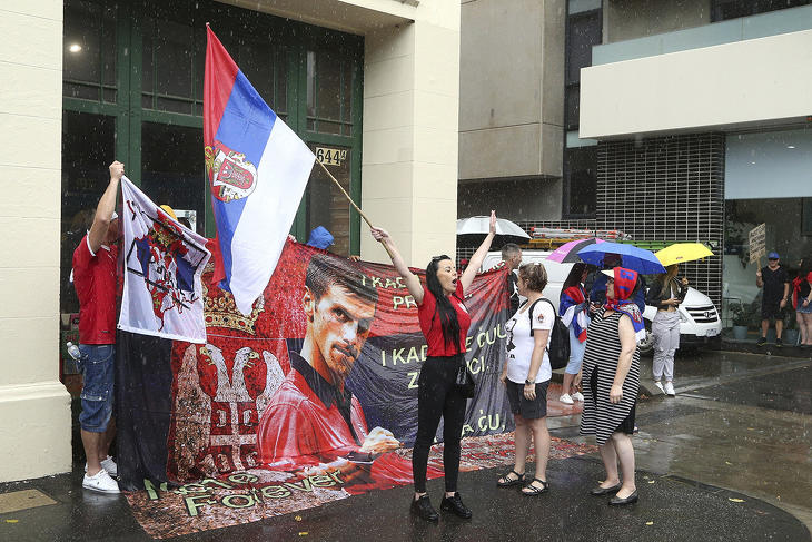 A világelső szerb teniszező, Novak Djokovic támogatói tüntetnek szerb zászlóval egy melbourne-i karanténhotel bejáratánál 2022. január 7-én. (Fotó: MTI/AP/Hamish Blair)
