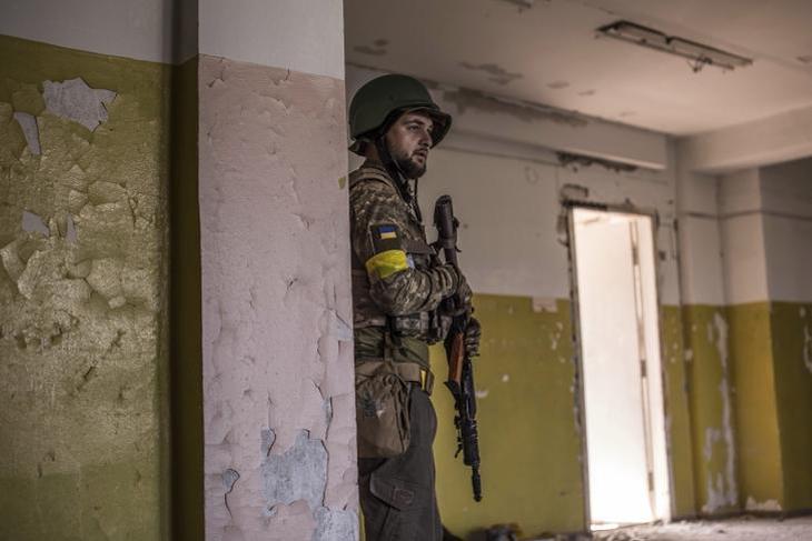 Ukrán katona egy lőállásnak használt épületben a keleti fronton. Fotó: MTI/AP/Olekszandr Ratusnyak