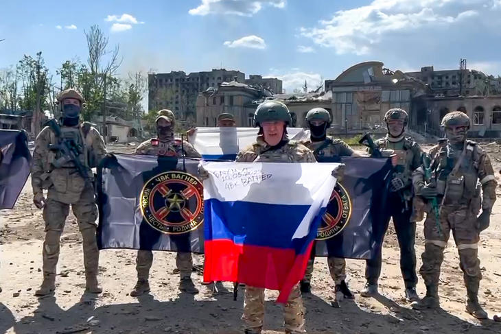 Bahmutnál is harcolnak a zsoldosok, akik büszkén mutogatják ezt a korábbi képet, amin még Prigozsin apja fogja az orosz zászlót. Fotó: MTI/AP/Jevgenyij Prigozsin sajtószolgálata